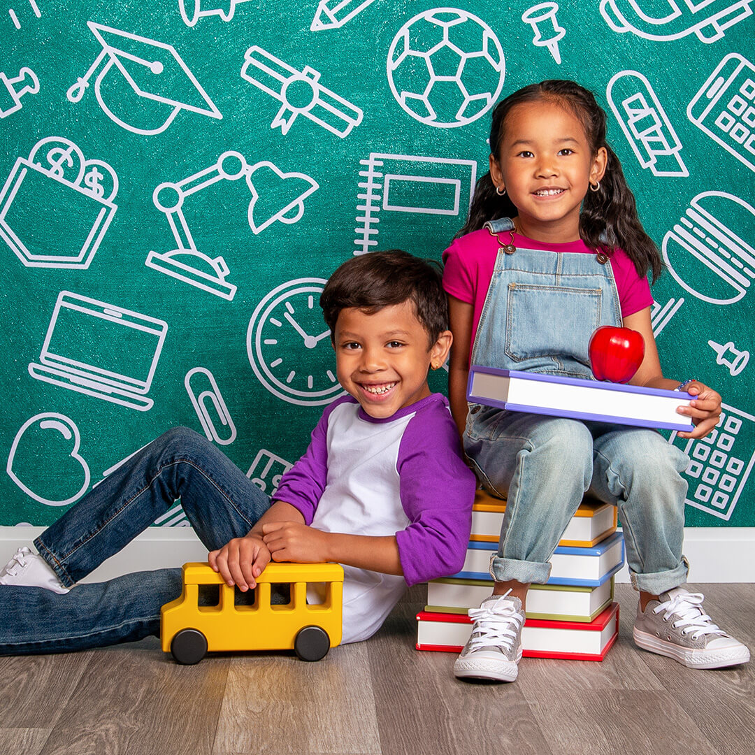 Siblings posing for back to school photos with props
