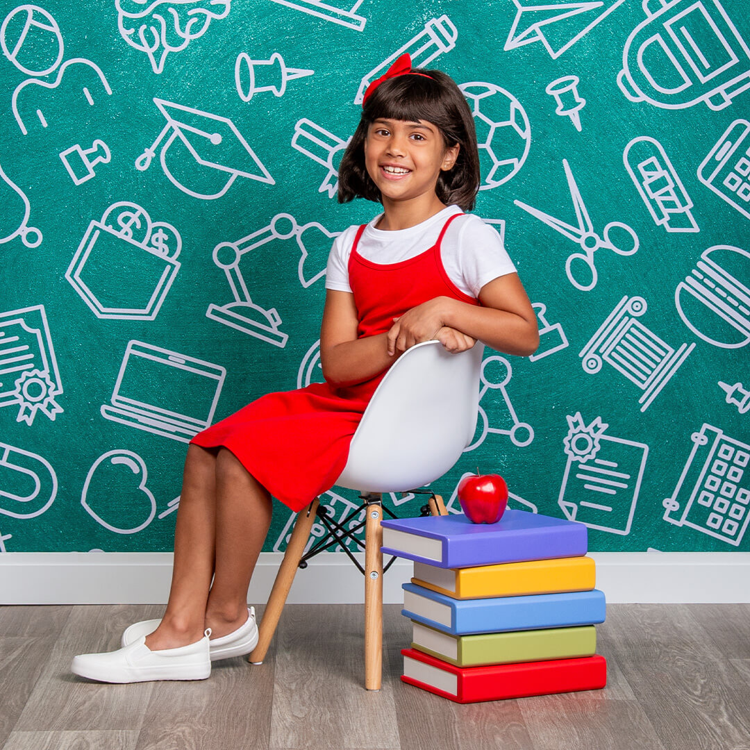 Girl sitting on a chair posing for back to school photos
