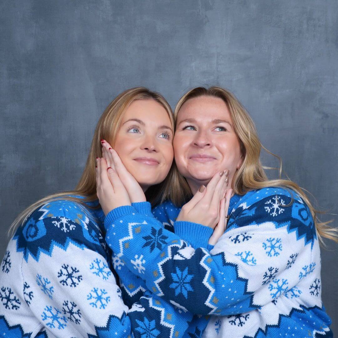 Friends in festive holiday sweaters posing for retro holiday photos
