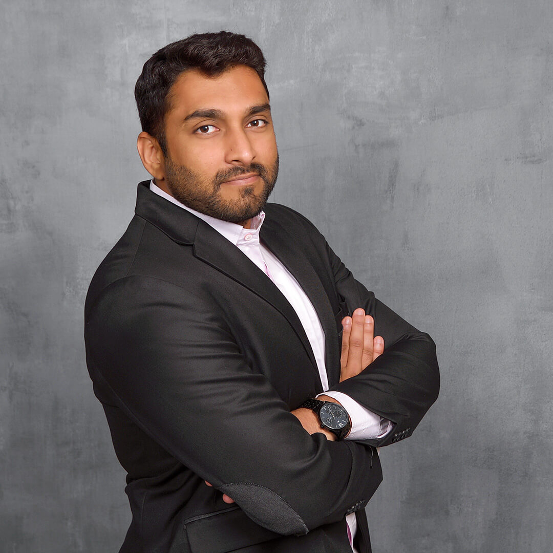 Man wearing a black suit posing for business headshots.